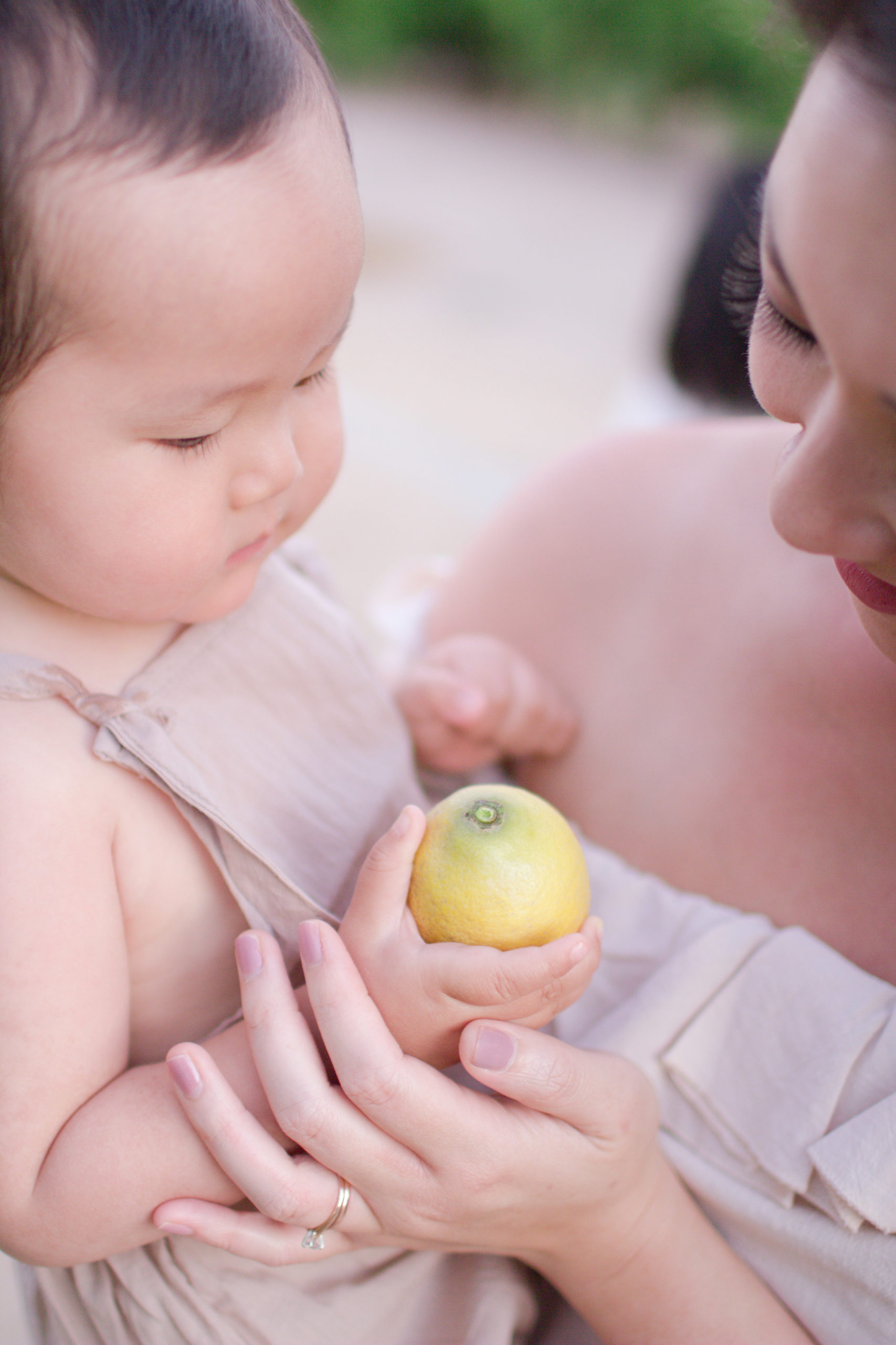 Baby Holds Lemon with Mother
